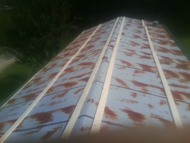 Rusted metal roof panels with new wood purlins before replacement — Storm Damage Roof Repair in Roaring Gap by Roofing Brothers